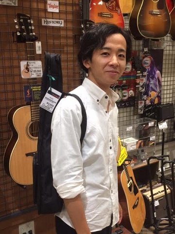 肩から掛けるとこういう感じになります。モデルは当店ギター教室講師の平野先生です。