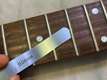 弦高が極端に低い訳でも無いのに特定のポジションでビビリ音が発生するという症状があります。 その原因のひとつとして上げられるのはフレット浮きです！ 指板材が月日と共に痩せていきフレットから離れていく場合や打ち込みが甘いなど様々な理由があります。 フレット浮きでも中心が浮きやすい個体、端が浮きやすい個体 [&hellip;]