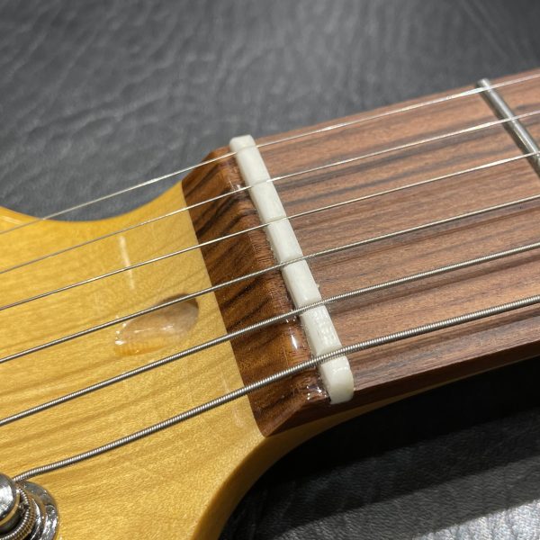【耐久性・チューニングの安定性に優れた牛骨ナット】<br />
牛骨で作られたナットは、耐久性が高く耳触りの良いトーンが得られます。素材自体のオイル成分が弦の滑りを良くるため、チューニングも安定します。