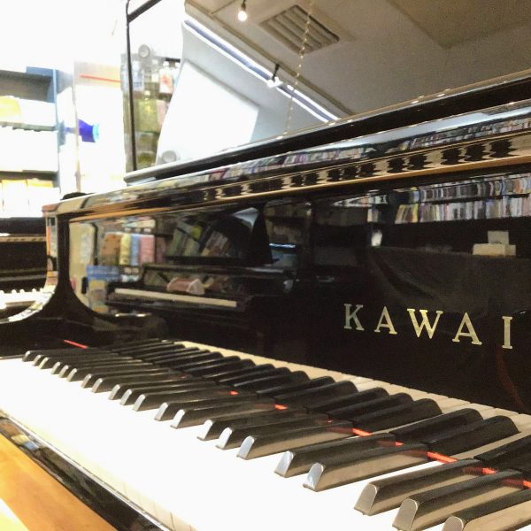 河合楽器のアップライトピアノの魅力の一つが垂直に立ち上がる鍵盤蓋。グランドピアノのデザイン性を強く意識した美しさが際立ちます。
