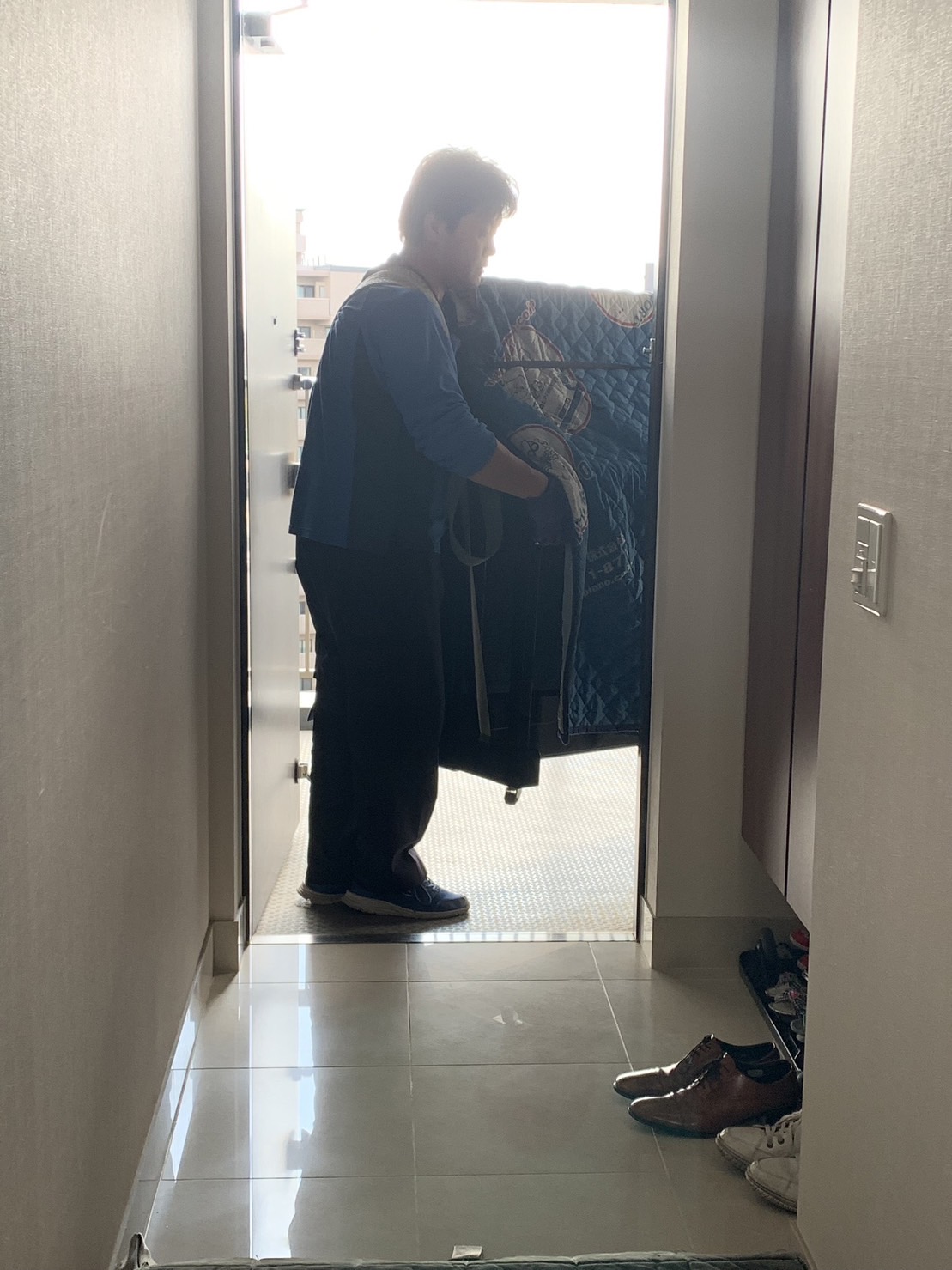 玄関から二人で担いで搬入します。