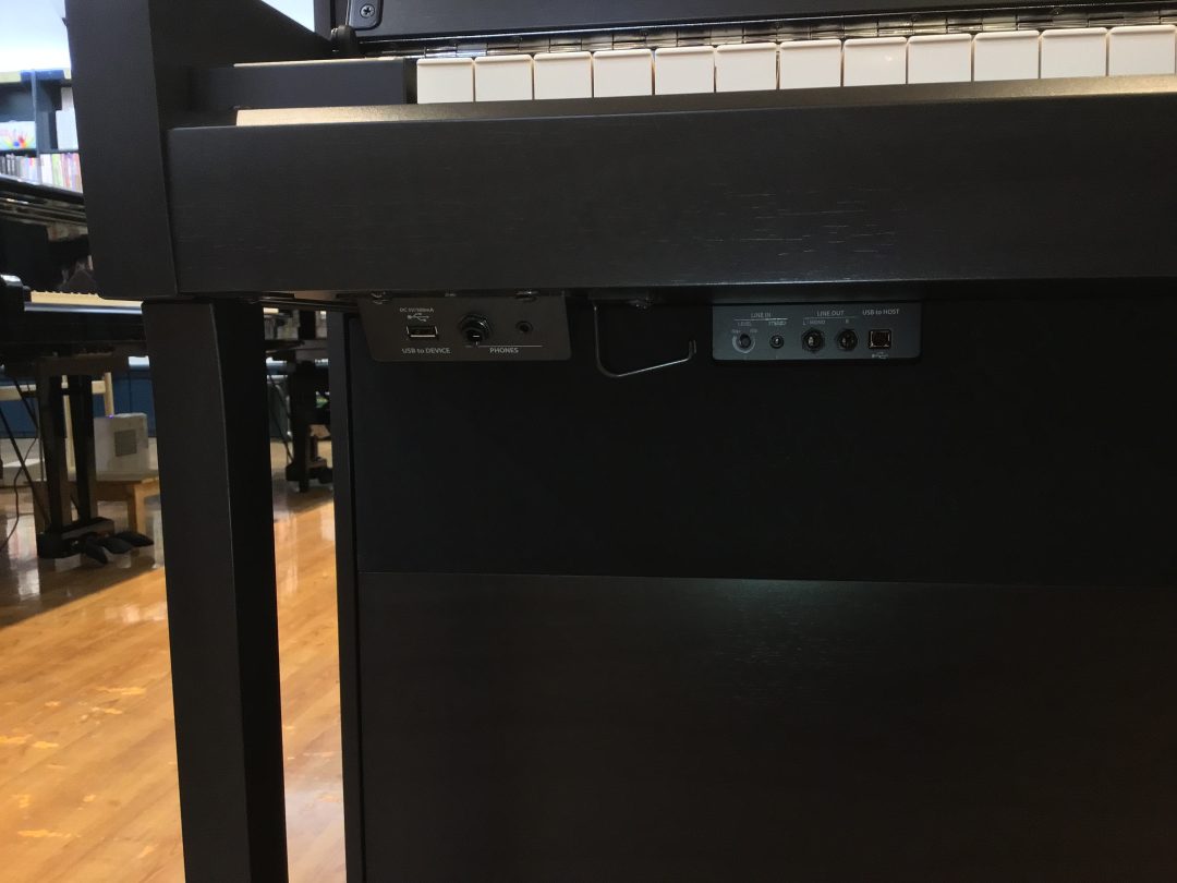 使いやすさ③インプットジャック関連は低音側の鍵盤下に全て配置されています。よく使うヘッドホンやUSBメモリーのジャックは手前に。右側にはヘッドホンの収納に便利なフック。やや奥に配置されているのがLINE（IN/OUT)でレベルの調整ツマミがあるのが便利です。