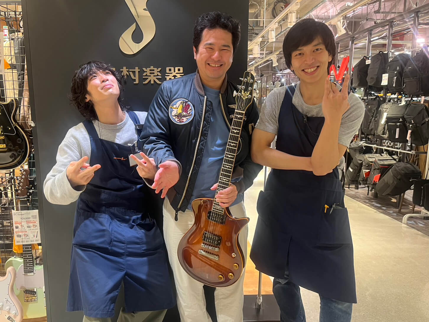 スタッフに挟まれて笑顔の写真