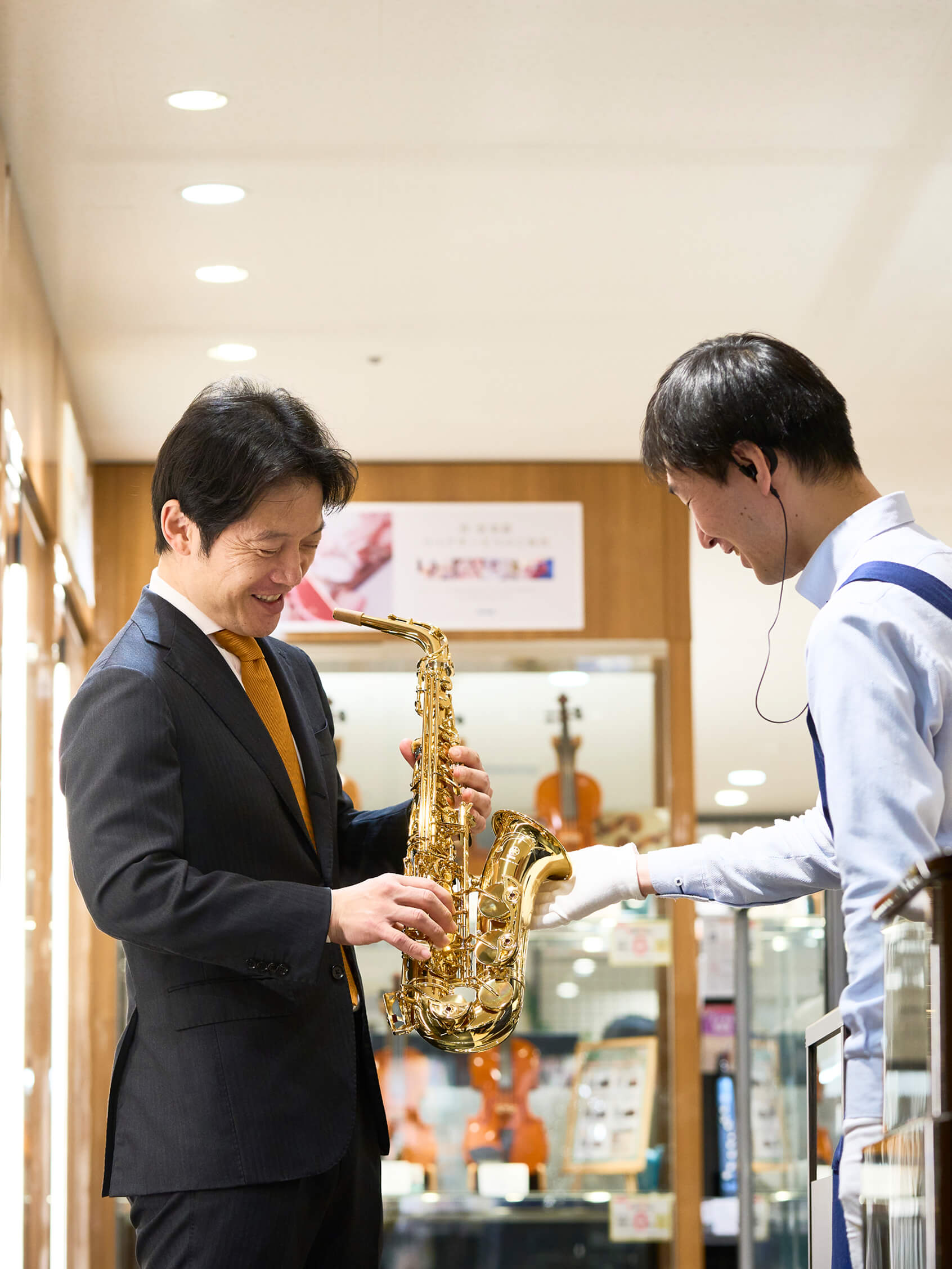 スタッフと社長が笑いながら管楽器をみて話をしている様子