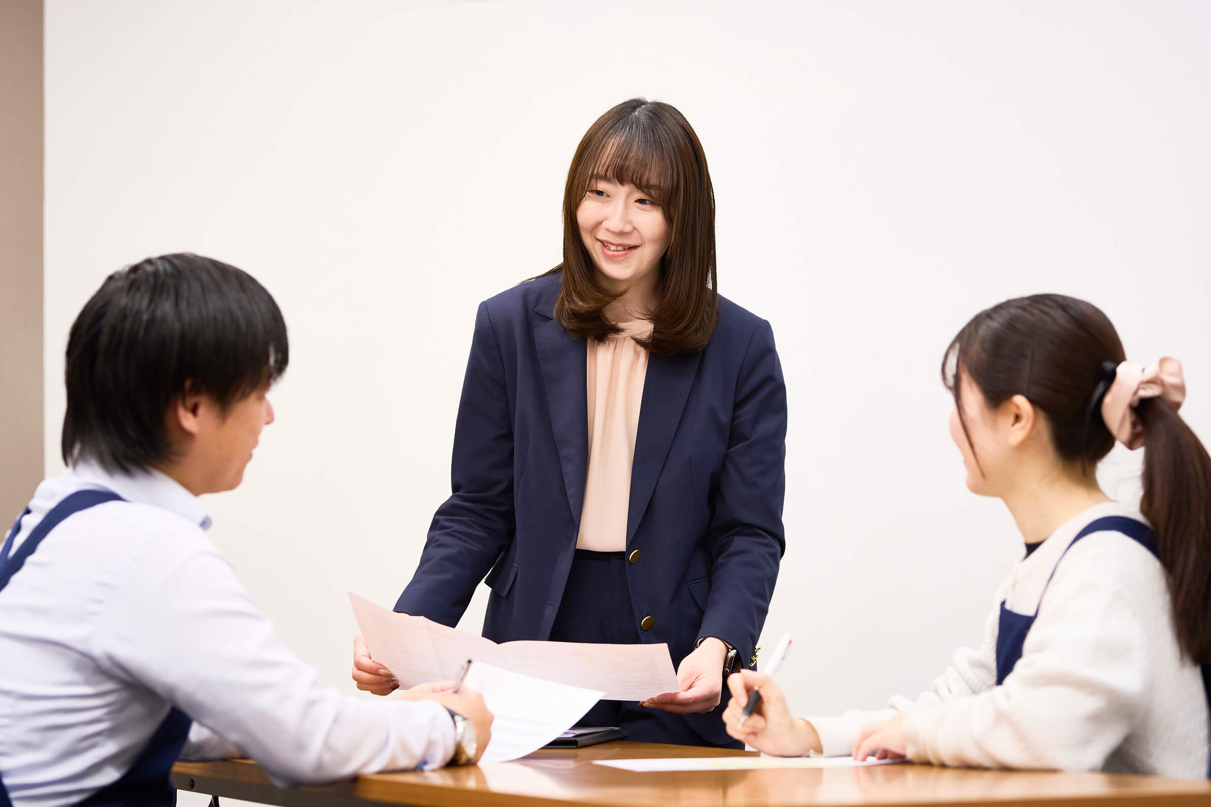 スタッフと資料を確認しながら打ち合わせをする
