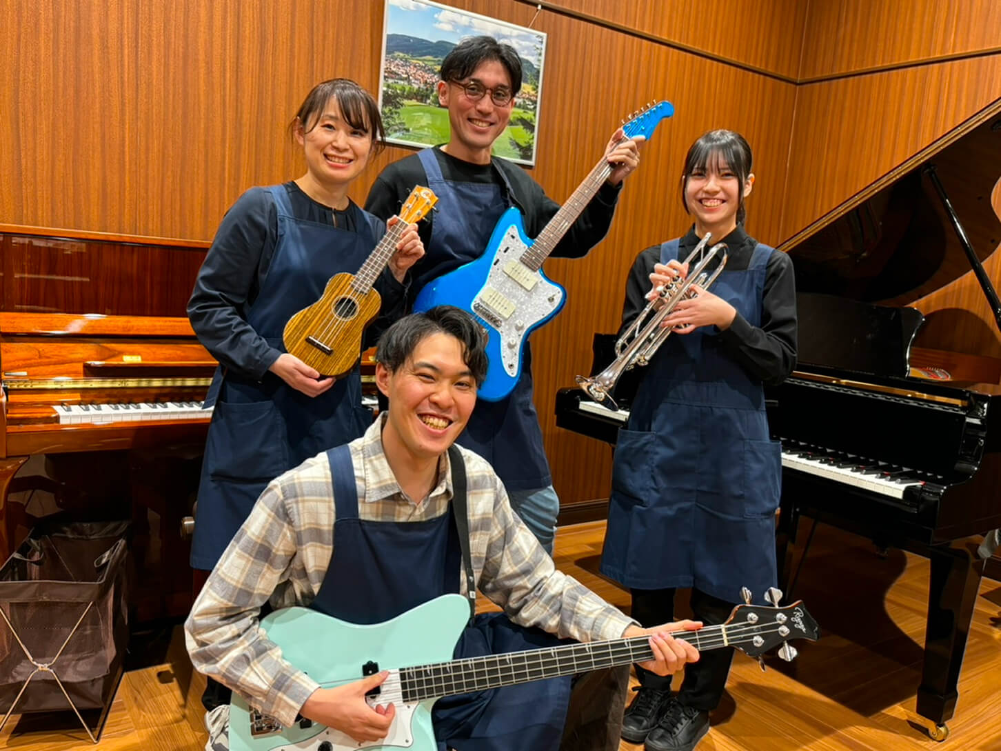 同僚と楽器を持ちながら笑顔の写真