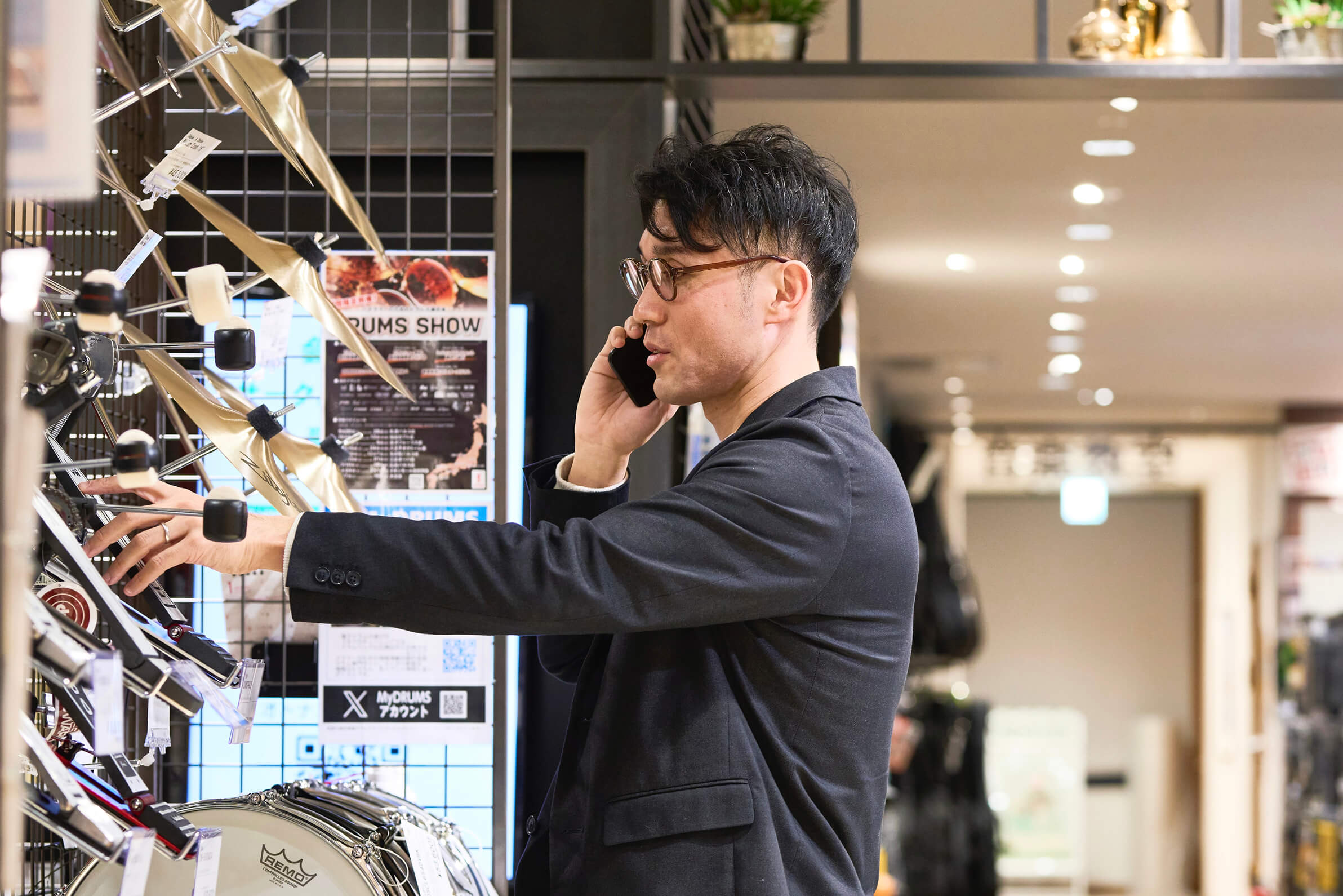 電話をしながら楽器の確認をする